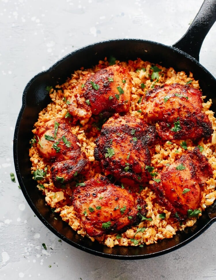 close up of a cast iron skillet containing chicken and cauliflower rice