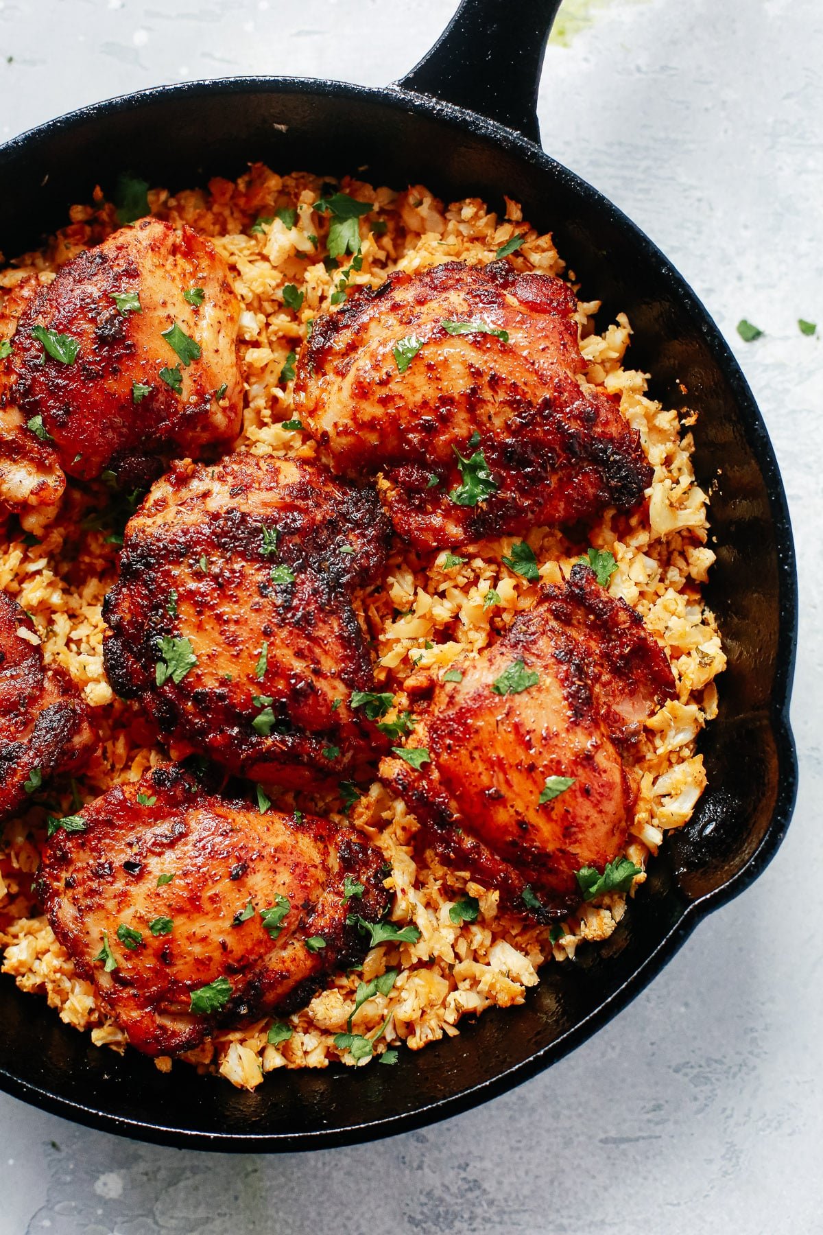 Chicken and cauliflower rice in a skillet.
