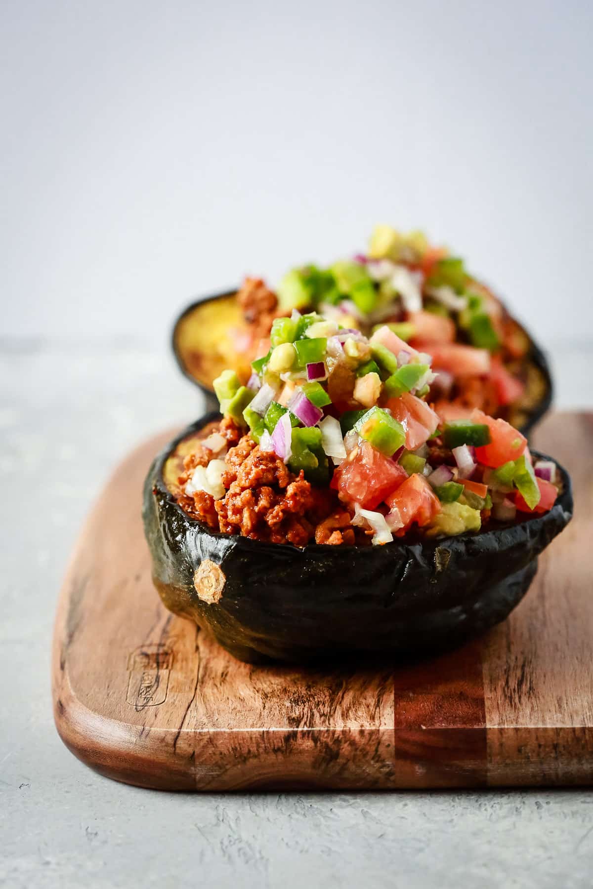 close up view of taco stuffed scorn squash on a wooden serving