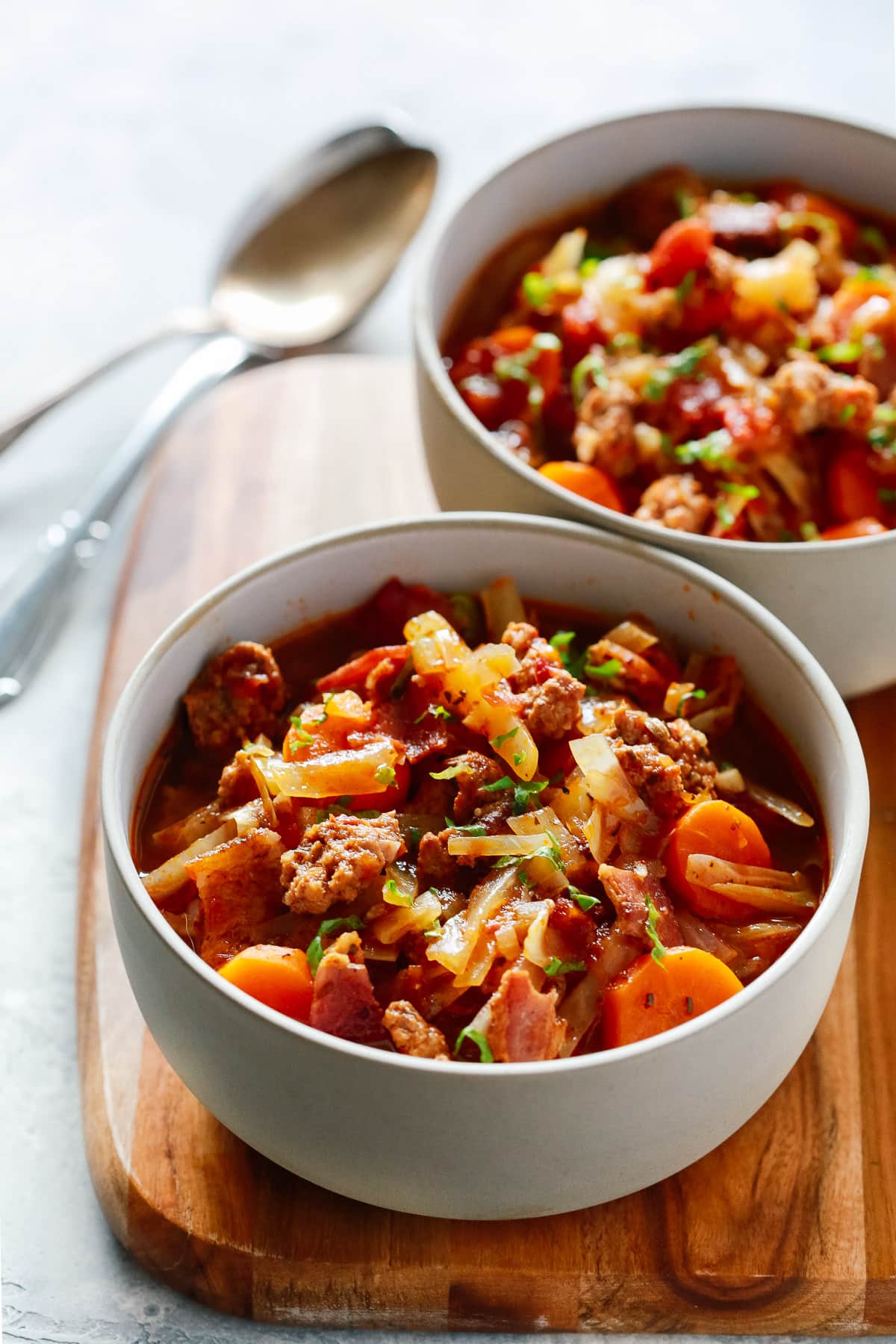 close up of cabbage and sausage in two grey bowls