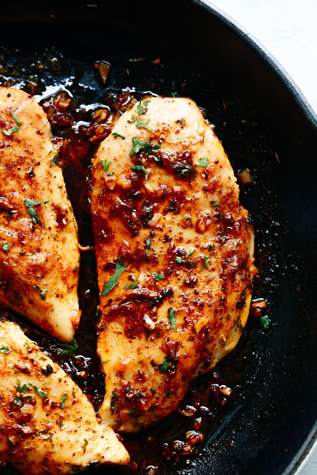 close up of a skillet filled with baked chicken breast