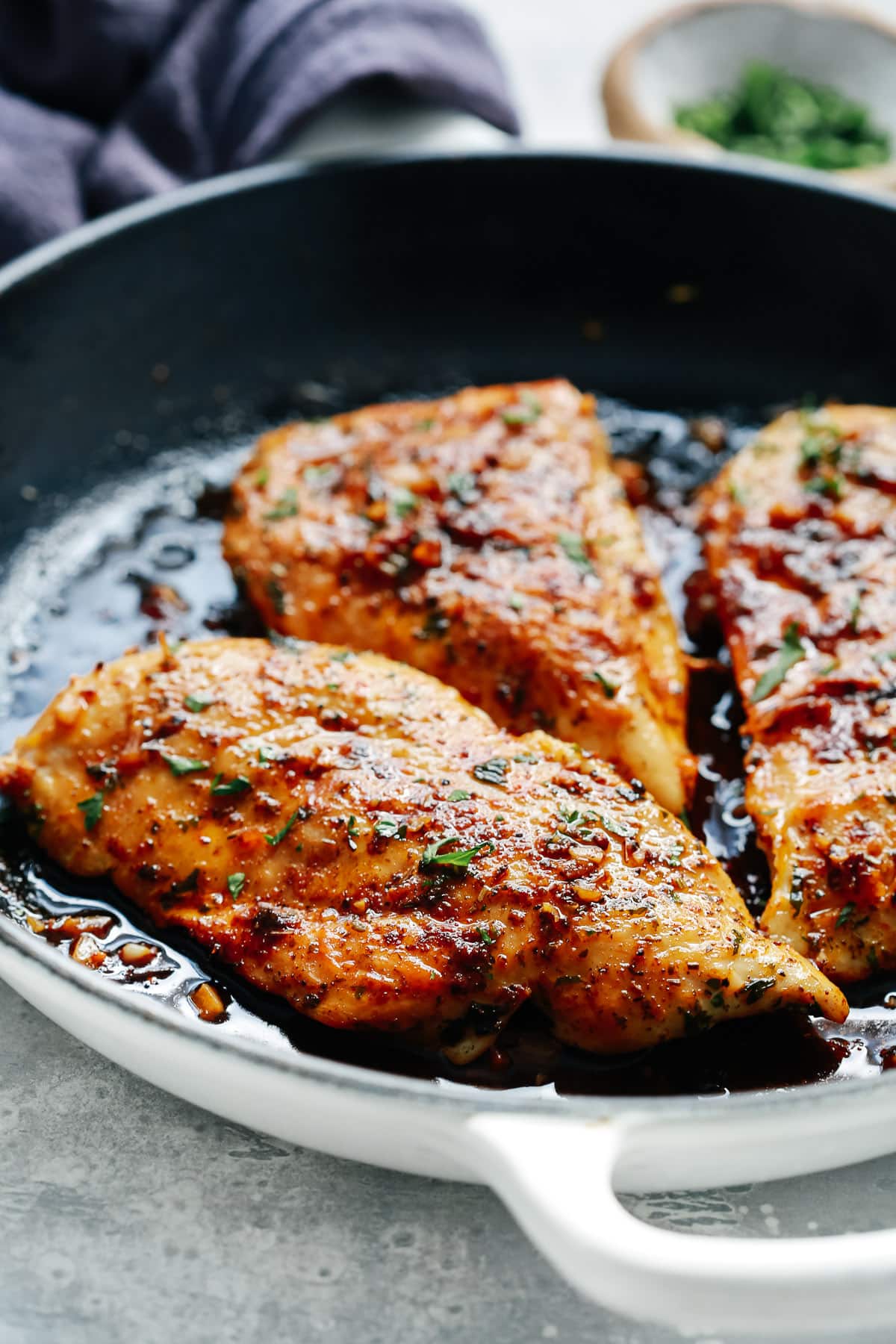 Closeup view of a cast iron skillet filled with cooked chicken 