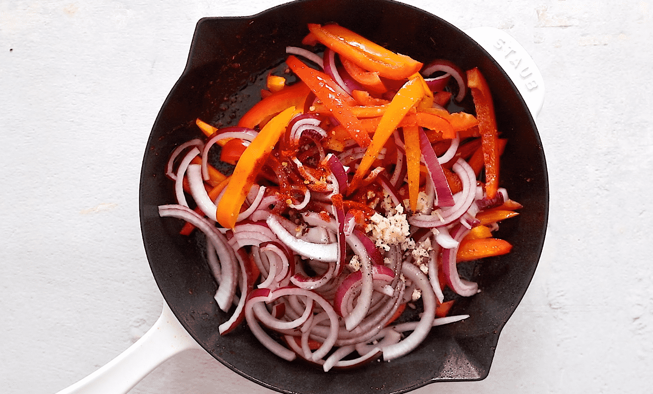 Bell pepper, onions and seasonings in a skillet