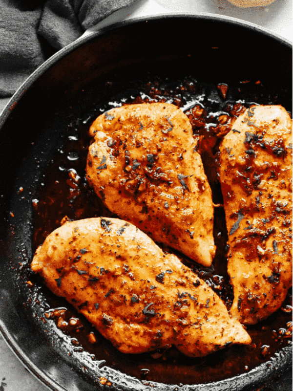 overhead view of three Garlic Butter Baked Chicken Breast in a cast iron skillet