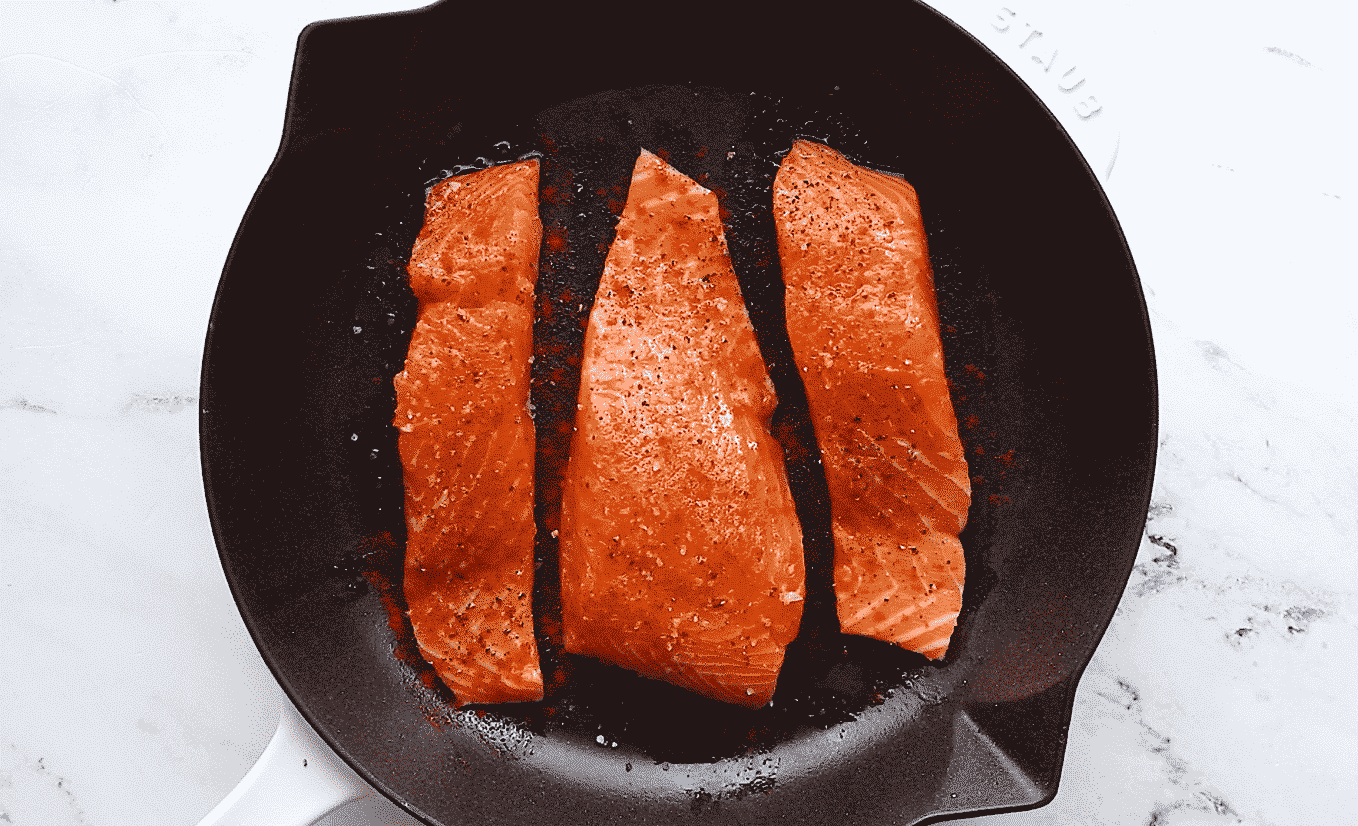 season salmon with salt, black pepper and paprika