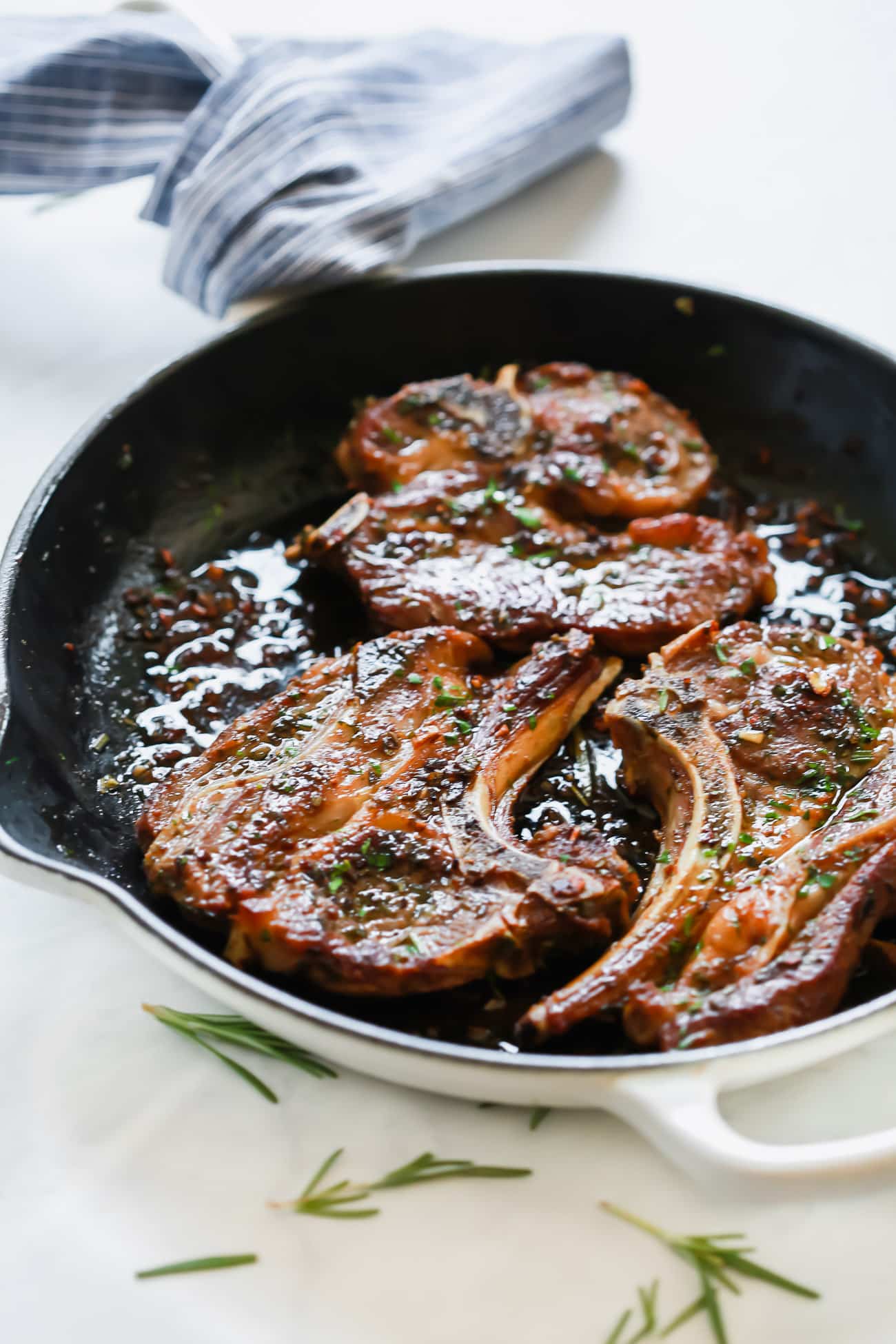 close up of a cast iron skillet containing lamb chops