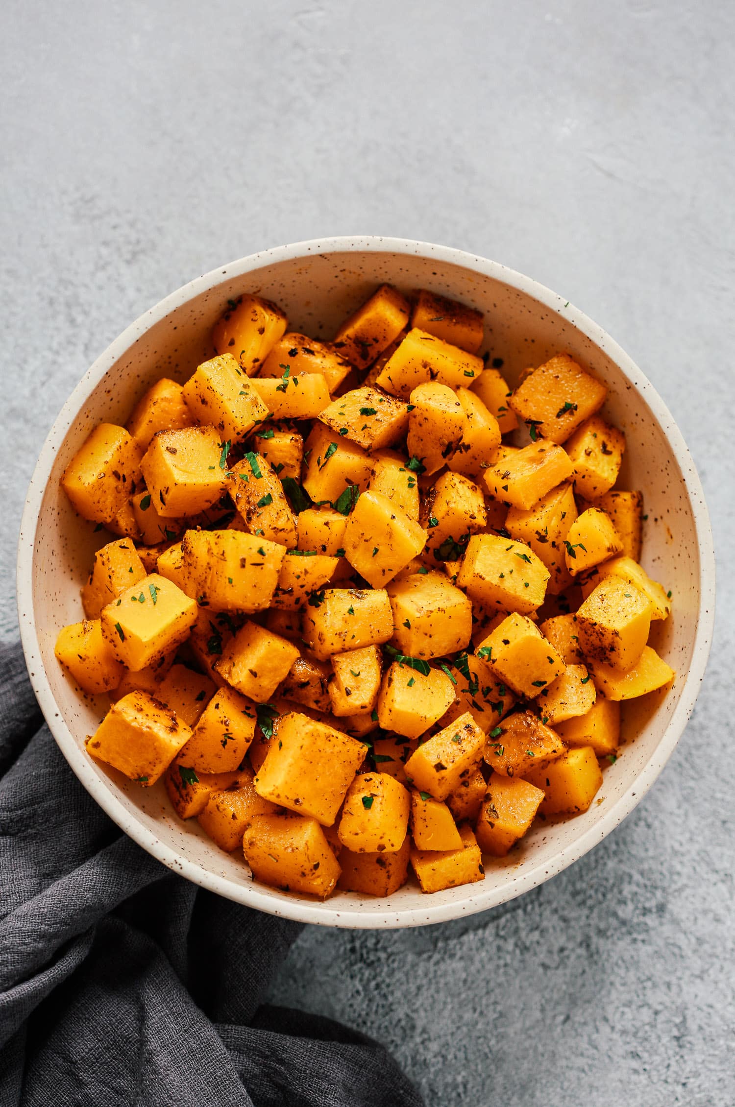 Overhead photo of a white bowl of roasted butternut squash.