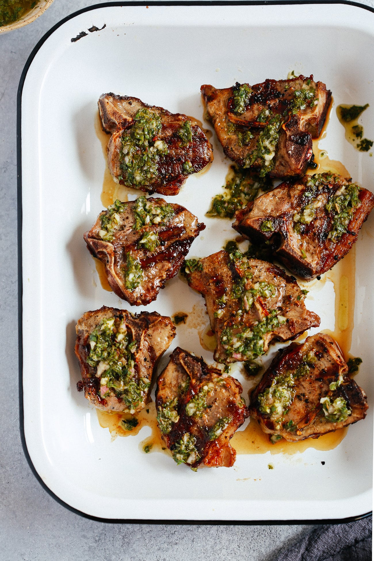 pan of freshly grilled lamb chops topped with chimichurri sauce