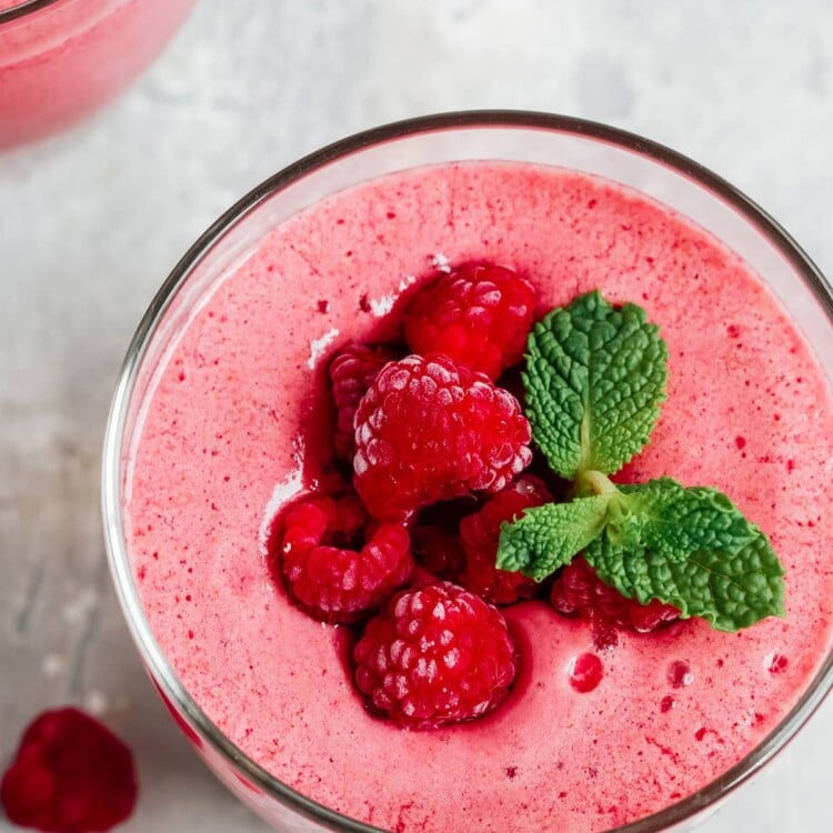 overhead view of a low carb raspberry smoothie garnished with fresh berries and mint