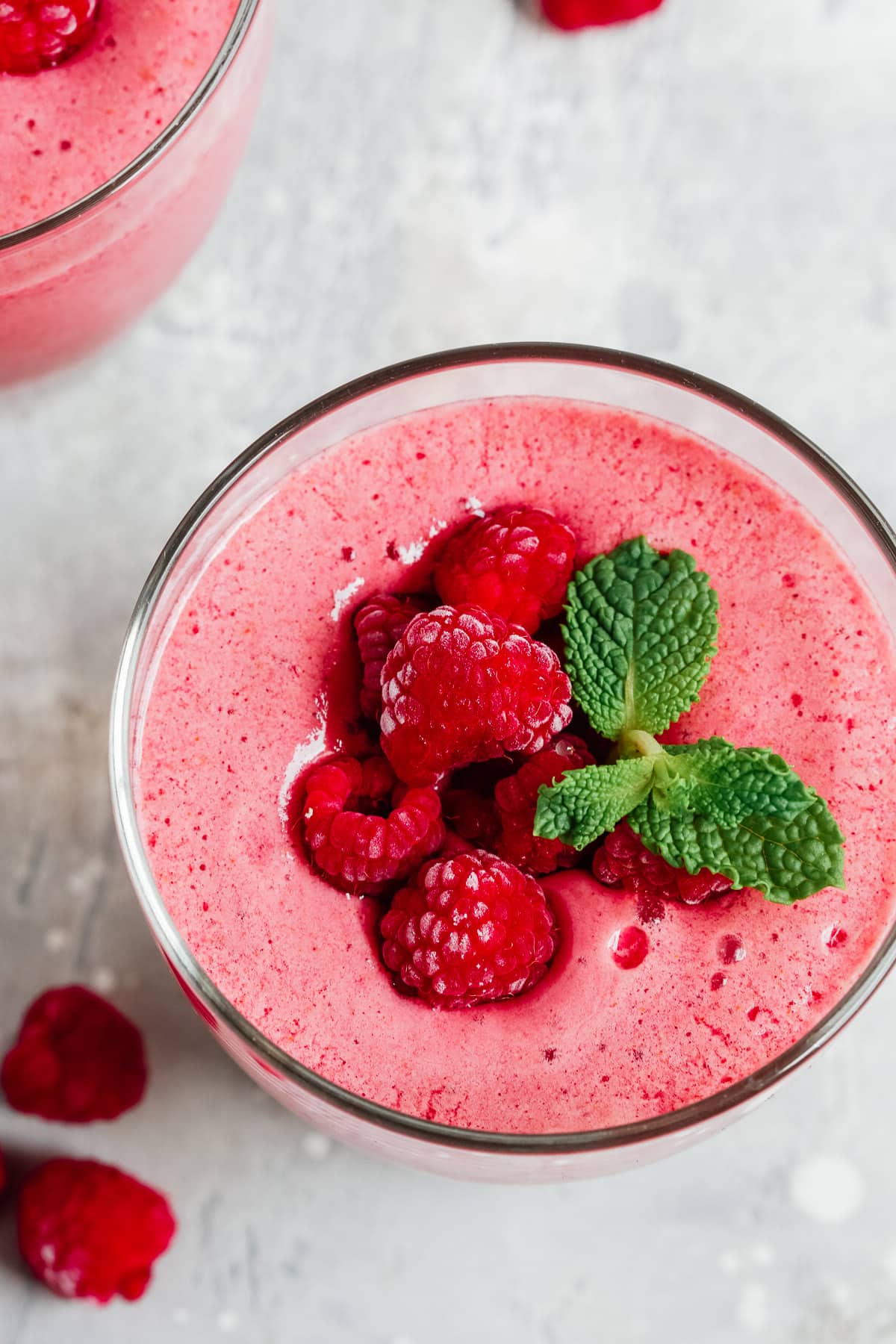 overhead view of a low carb raspberry smoothie garnished with fresh berries and mint