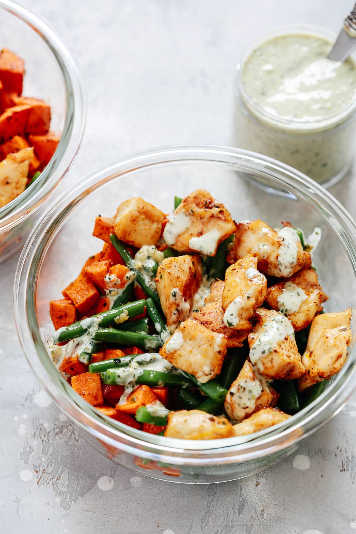 chicken and vegetables in creamy pesto sauce in meal prep recipe container