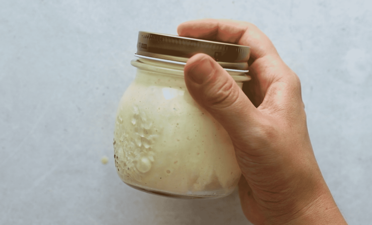 overhead view of a mason jar containing broccoli salad dressing