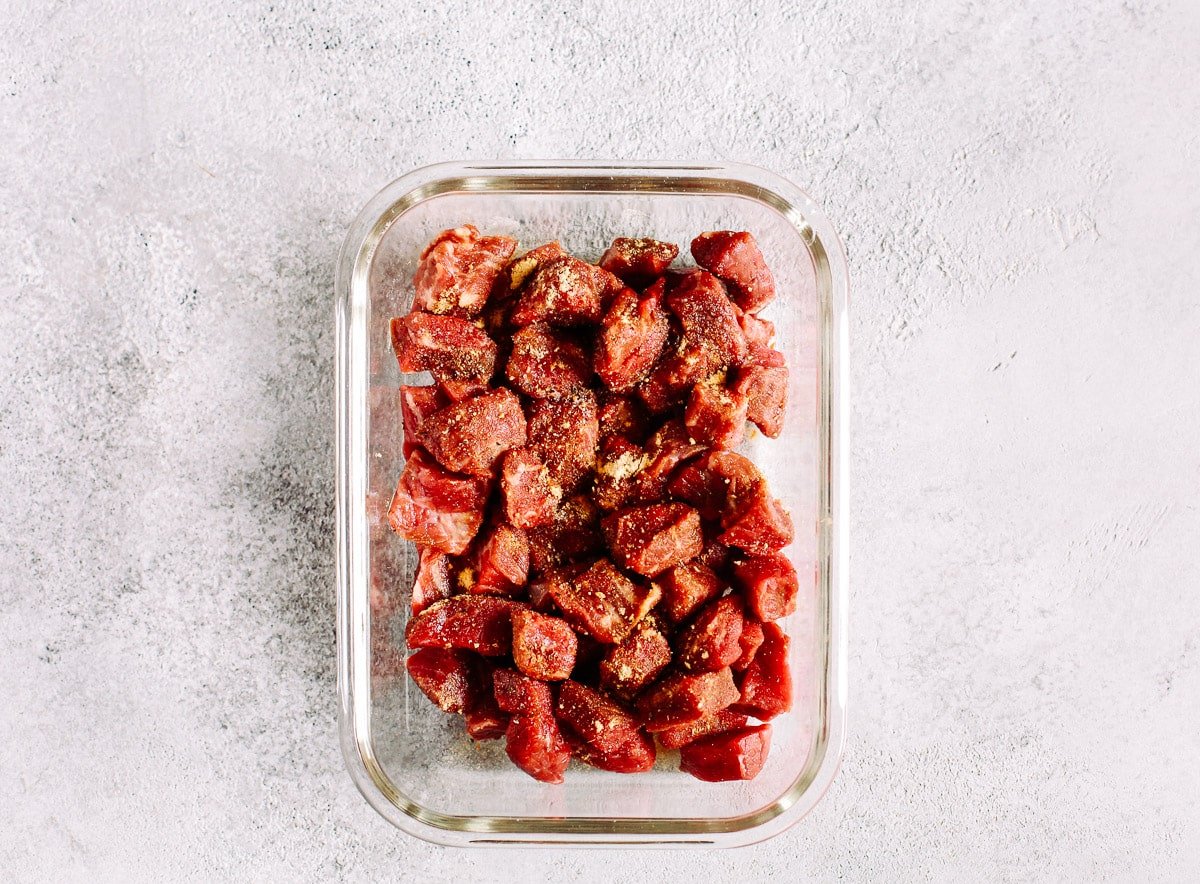 Steak bites are a fast and easy way to enjoy a steak dinner on a weeknight. Keep some in your fridge to add protein to any meal, any time. This steak recipe is quick and easy to make, too! raw beef sirloin in glass meal prep container