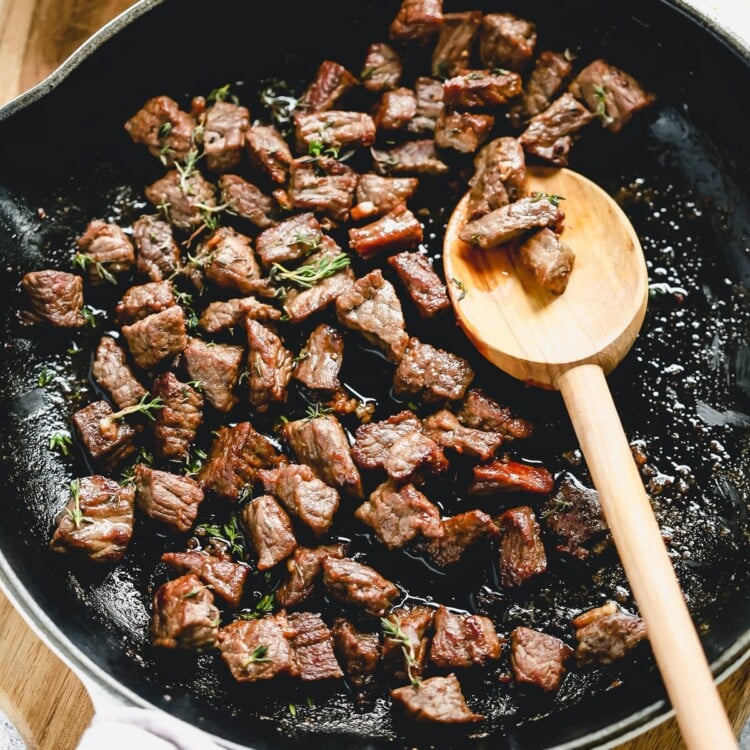 steak bites cooking in a skillet