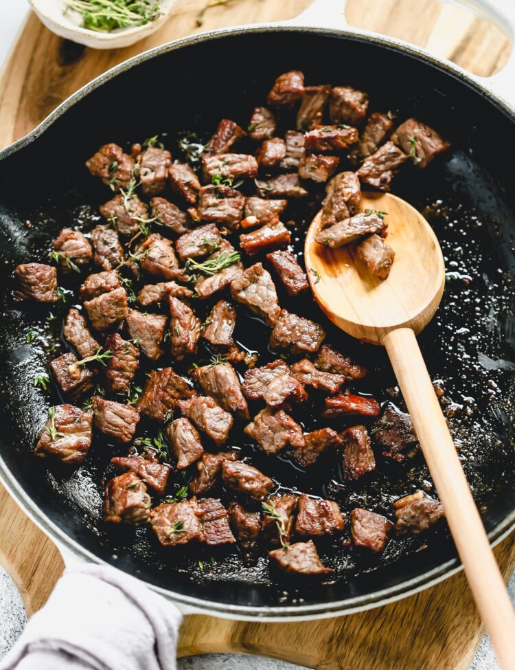 steak bites cooking in a skillet