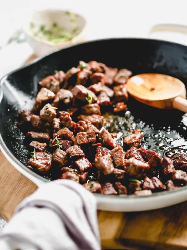 steak bites cooking in a skillet