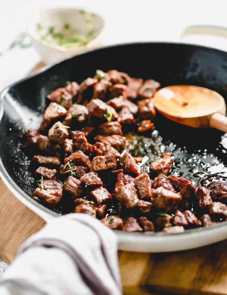 steak bites cooking in a skillet