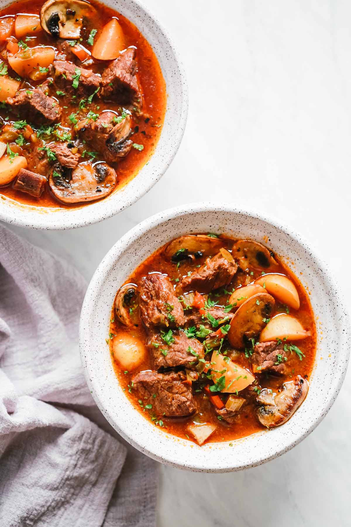 Overhead view of two bowls containing beef stew 