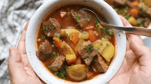 overhead view of a white bowl containing beef stew