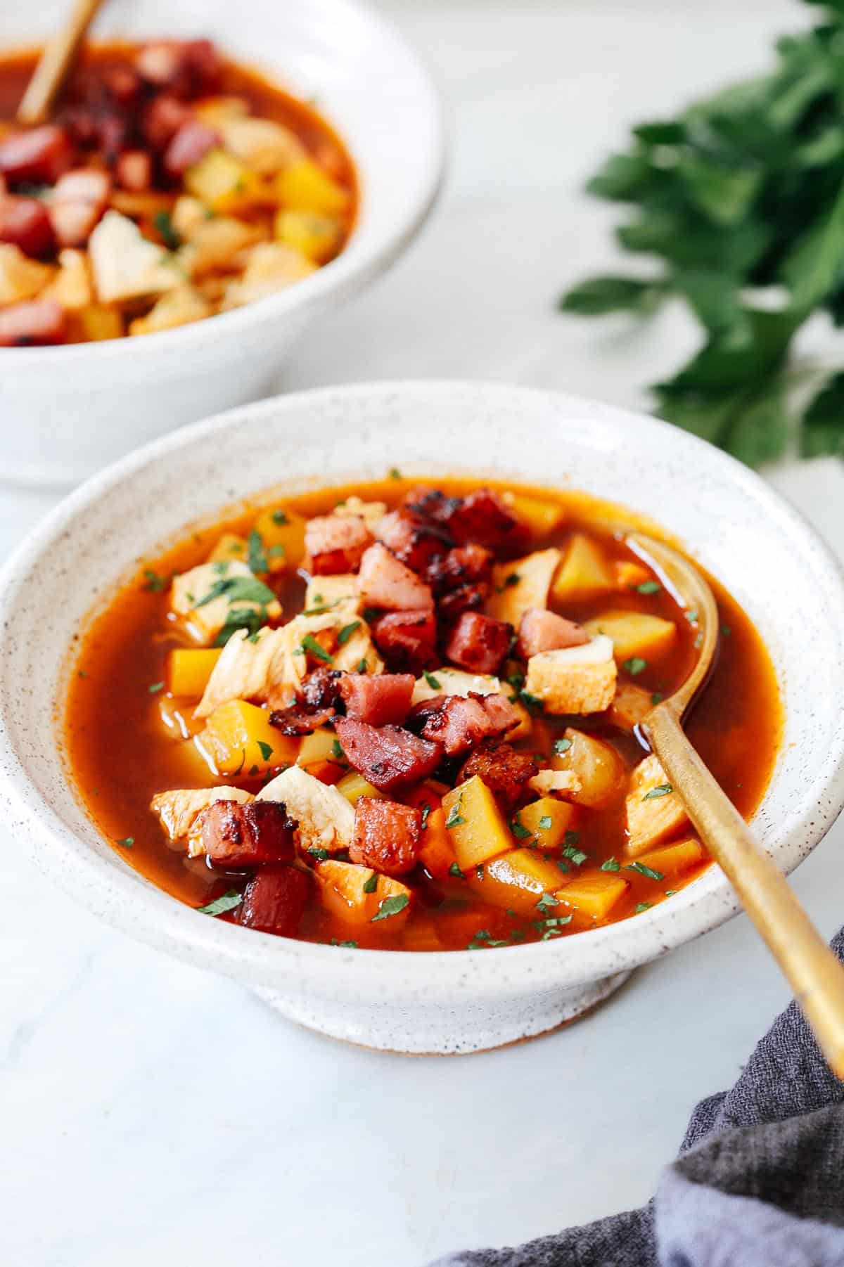 turkey soup with a spoon inside of the bowl