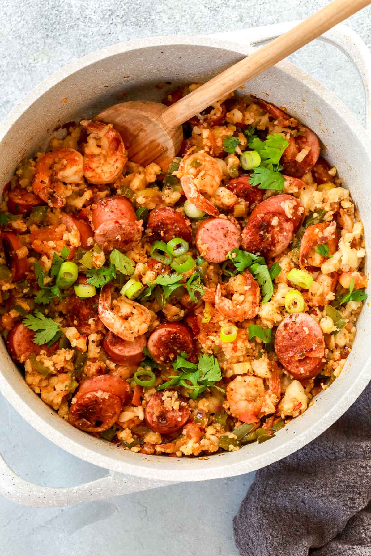 Grey pot of whole30 jambalaya with a spoon inside.