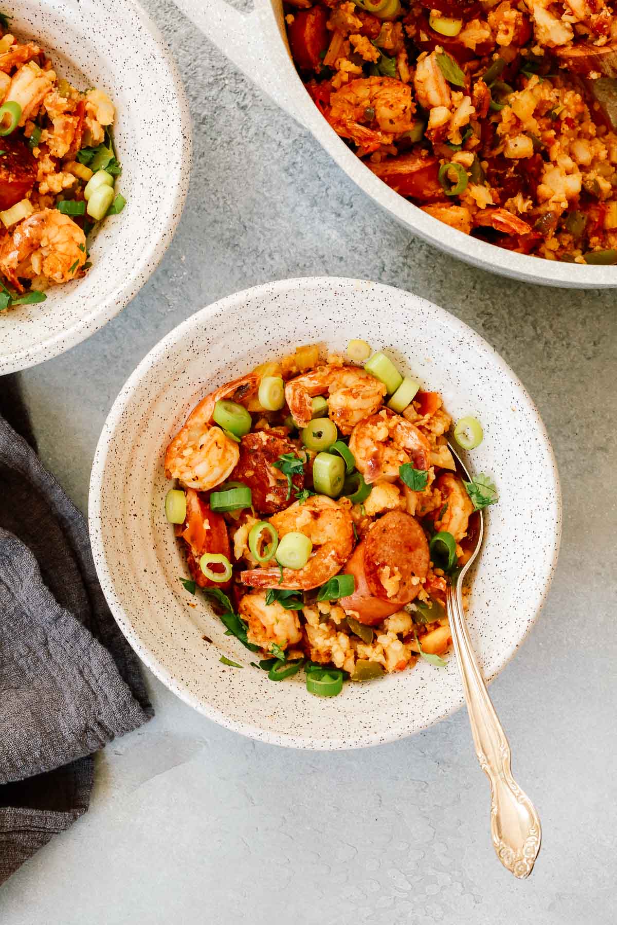 White bowl containing a Whole30 shrimp jambalaya recipe with a spoon inside.
