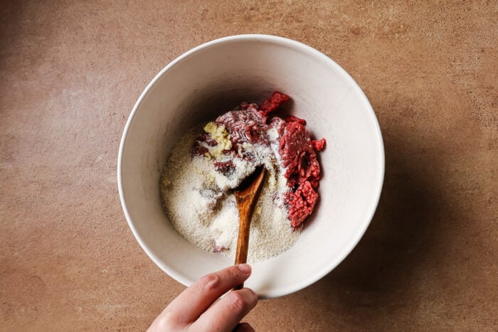Ingredients to make cocktail meatballs in a white bowl.