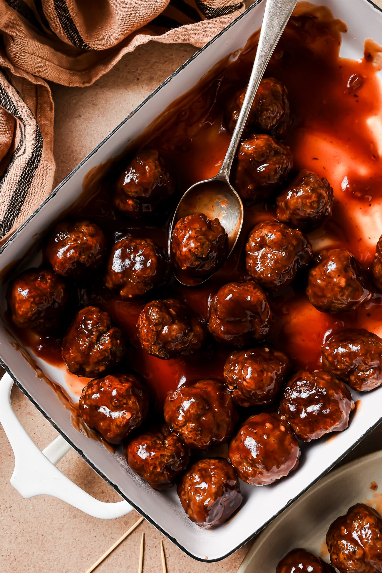 Overhead view of cocktail meatballs in a casserole dish.