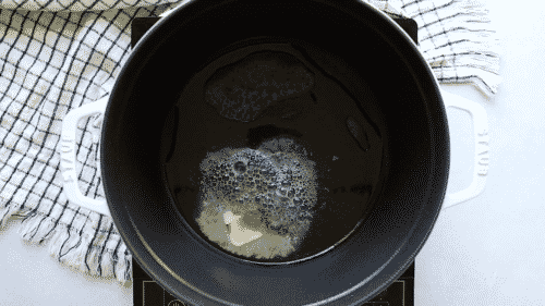 olive oil and melted butter in a white cast iron pot