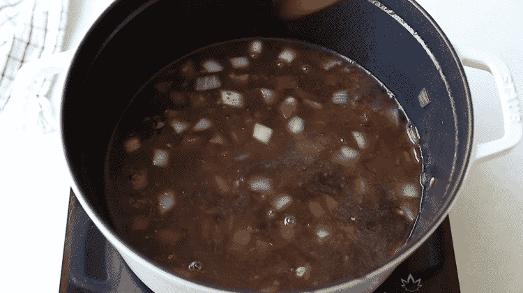 overhead view of wine and beef stock in a Dutch oven pot