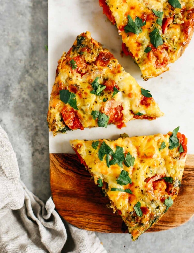 vegetable frittata cut into pieces on a wooden serving board