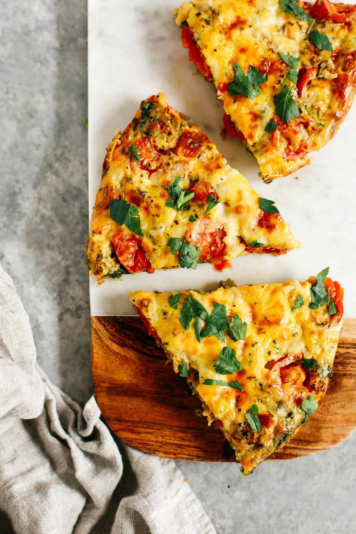 vegetable frittata cut into pieces on a wooden serving board