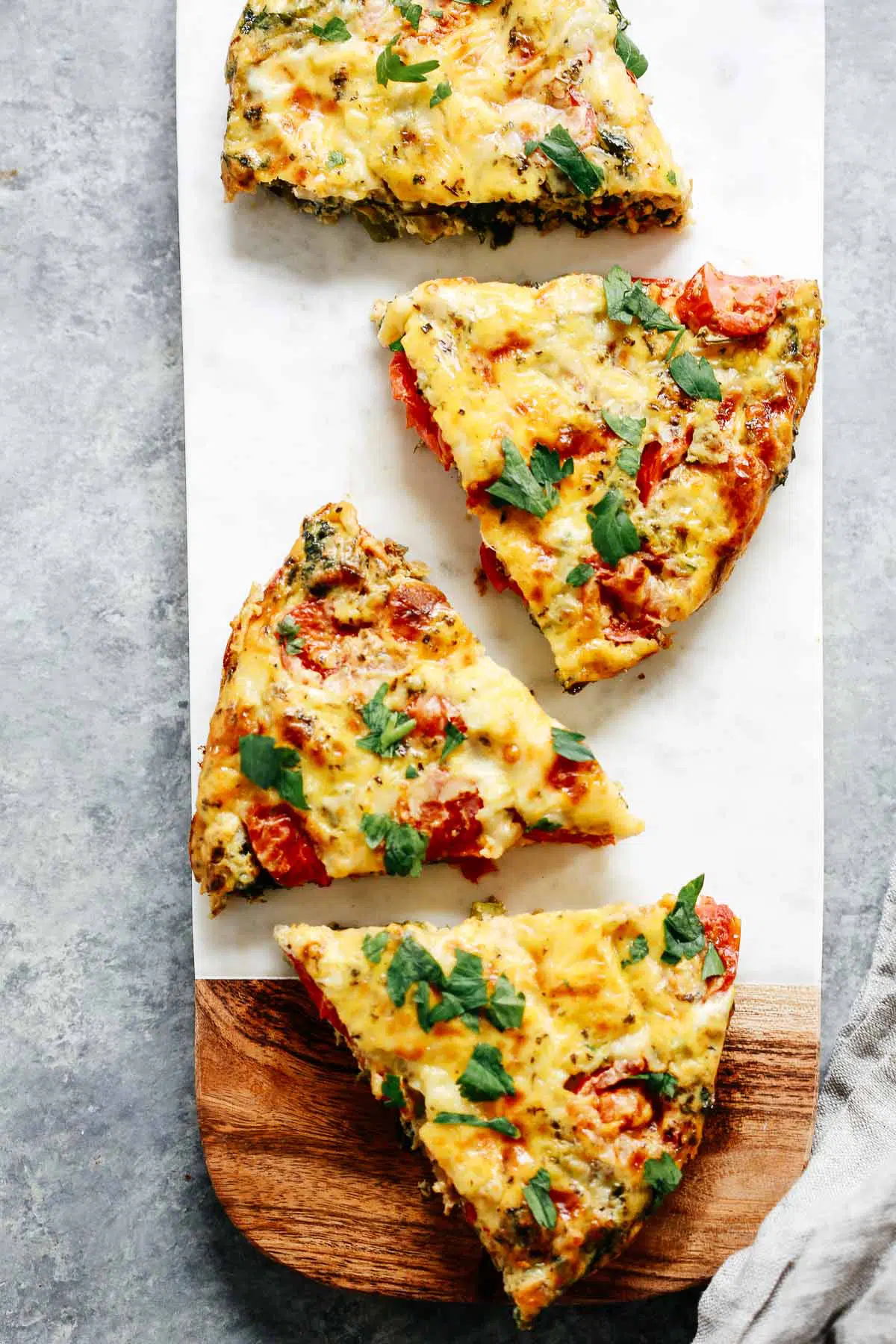 Slices of egg frittata with cherry tomatoes, kale and asparagus