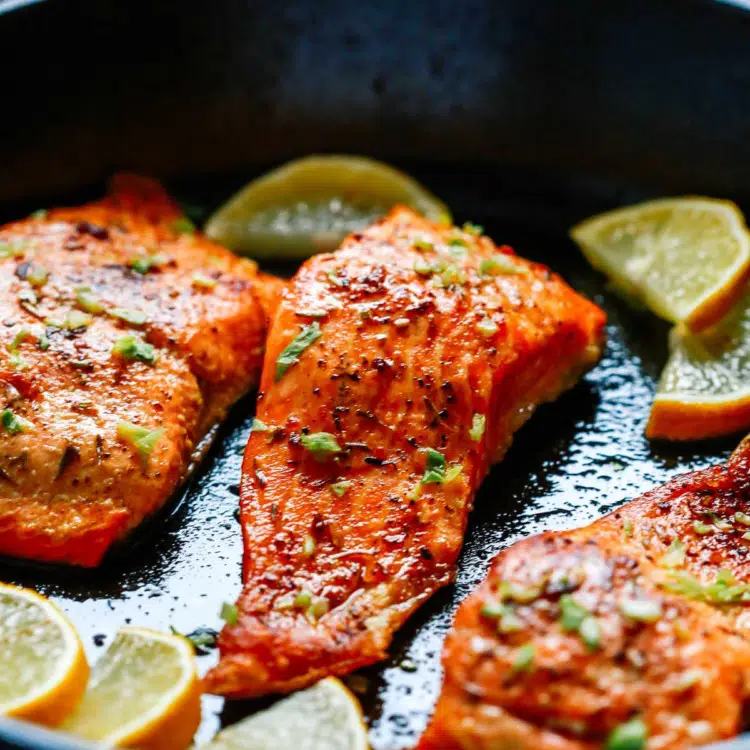 close up of broiled salmon in a cast iron skillet