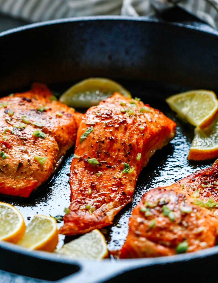close up of broiled salmon in a cast iron skillet