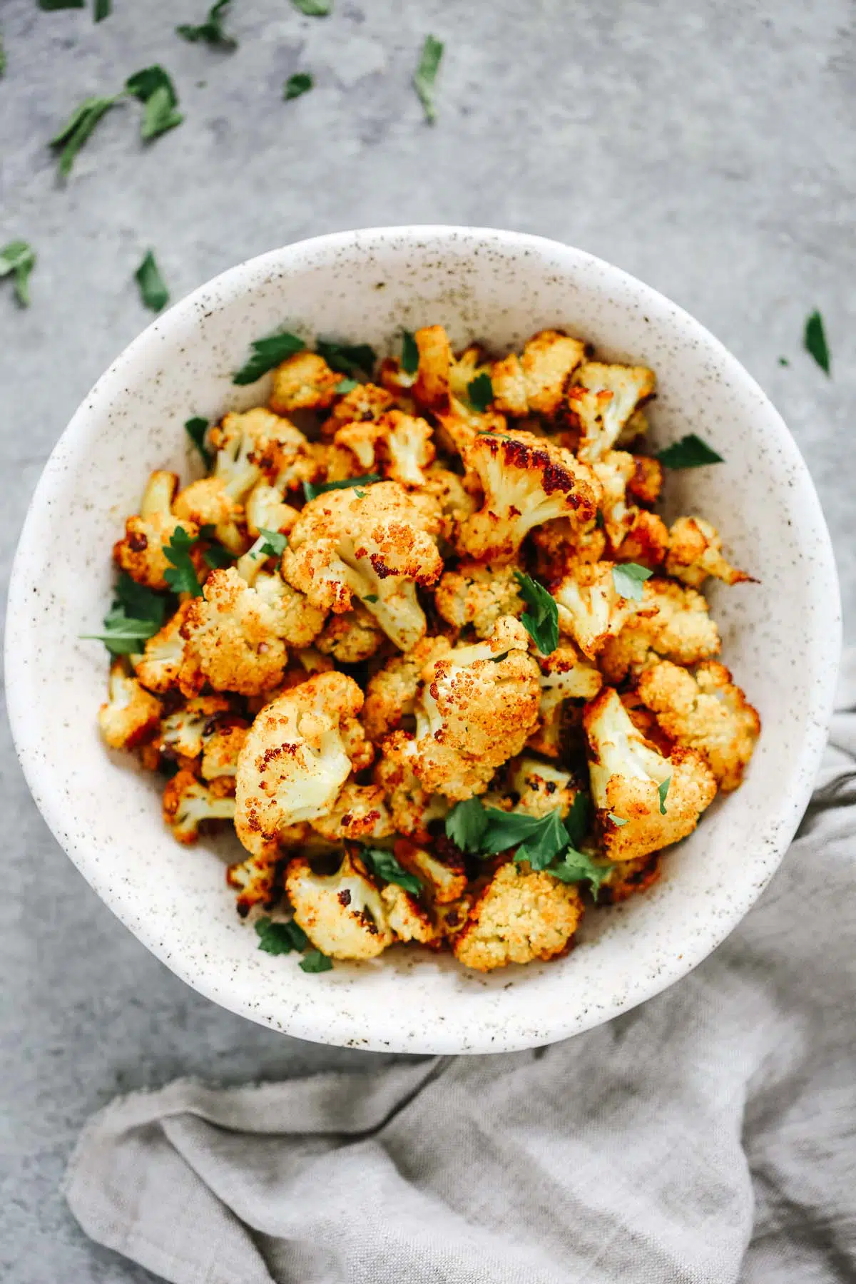 Overhead photo of roasted cauliflower in a white bowl. 