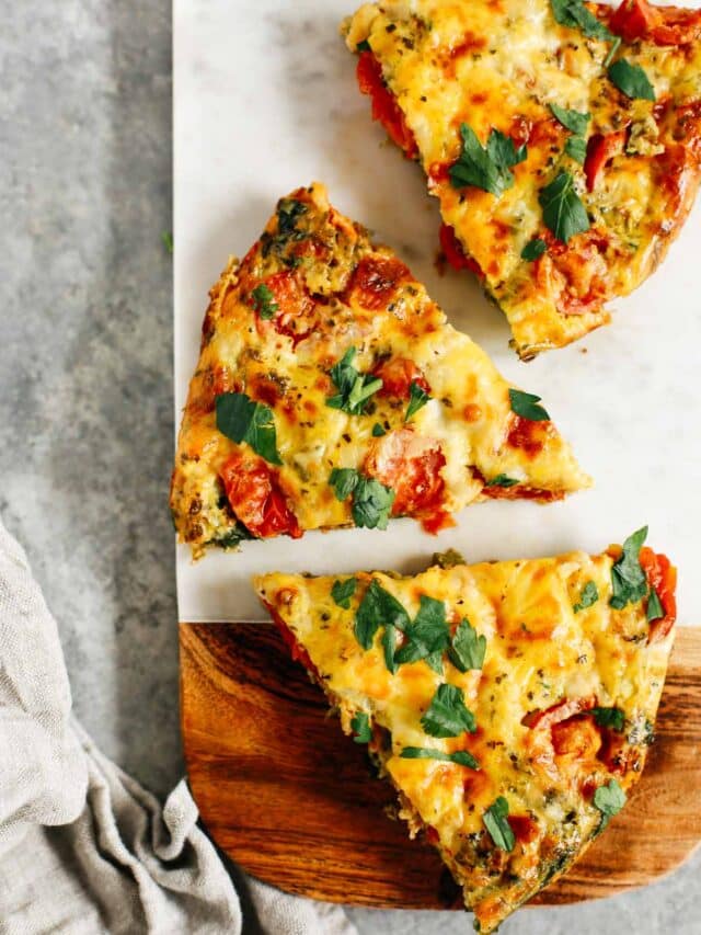 vegetable frittata cut into pieces on a wooden serving board