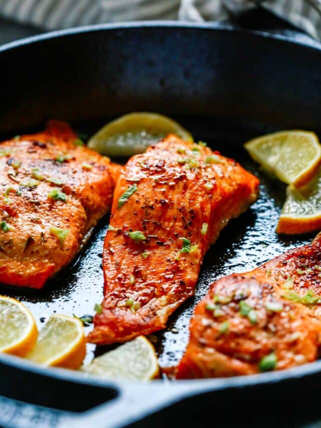 close up of broiled salmon in a cast iron skillet