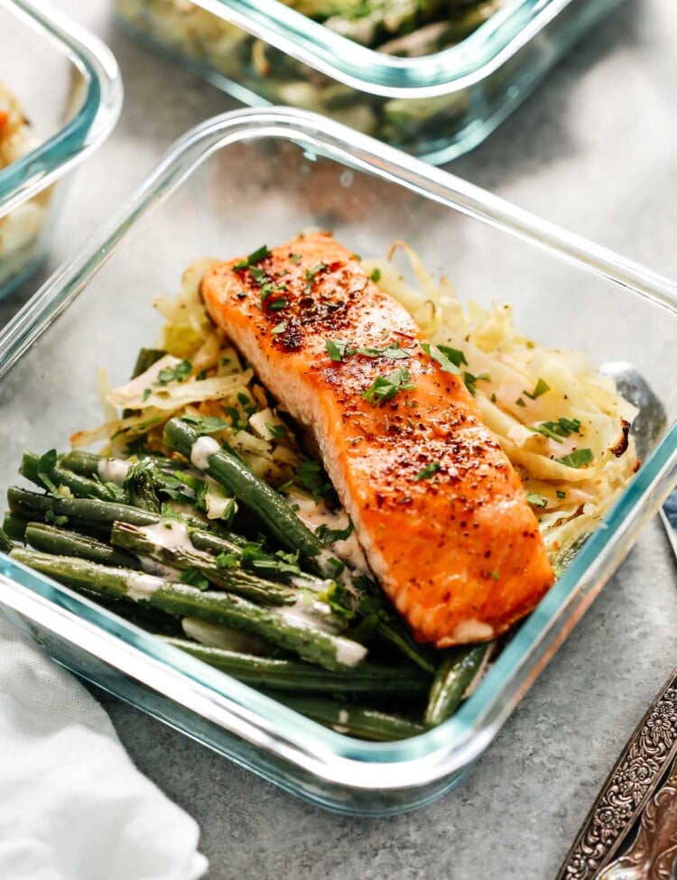 broiled salmon filet in meal prep container with green beans and cabbage