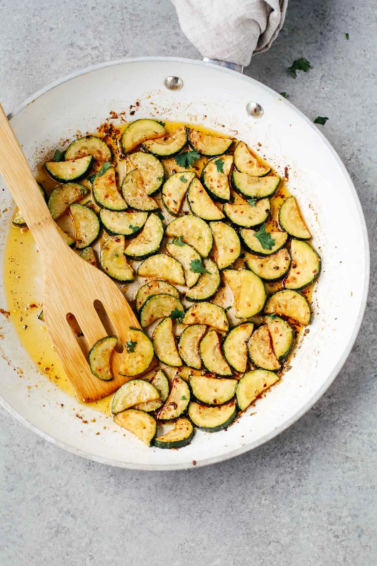 overhead image: making a garlic butter zucchini recipe in a skillet on the stove.