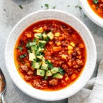 overhead view of a bowl of Mexican taco soup with chopped avocado garnish
