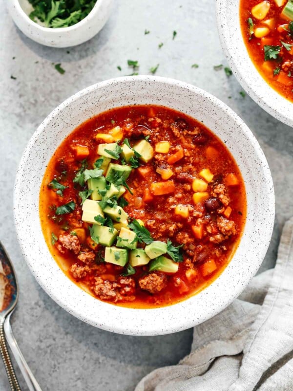 overhead view of a bowl of Mexican taco soup with chopped avocado garnish