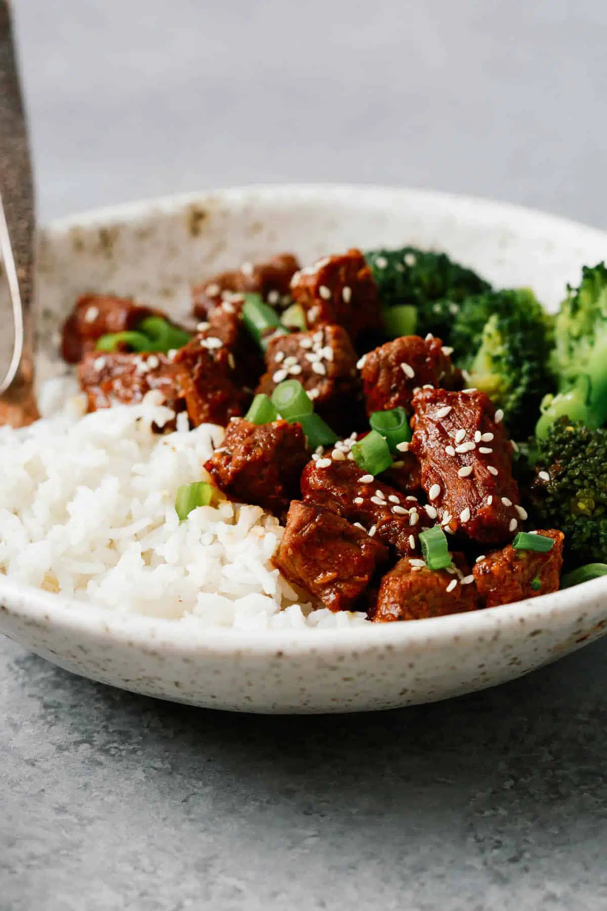  Instant Pot Korean beef on white plate with sides of white rice and steamed broccoli 