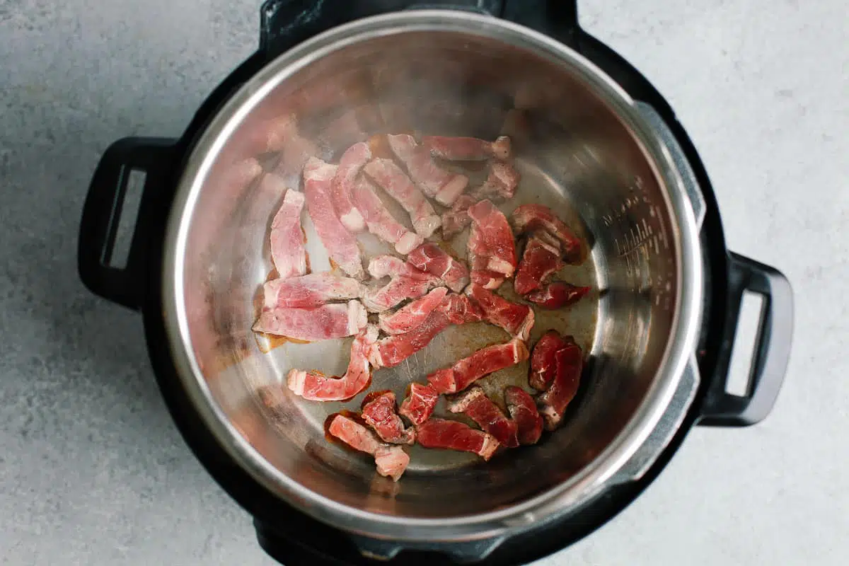 Strips of steak being browned in an Instant Pot