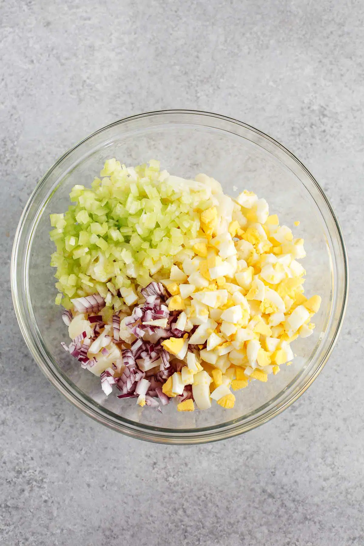 overhead view of a glass bowl containing cauliflower potato salad