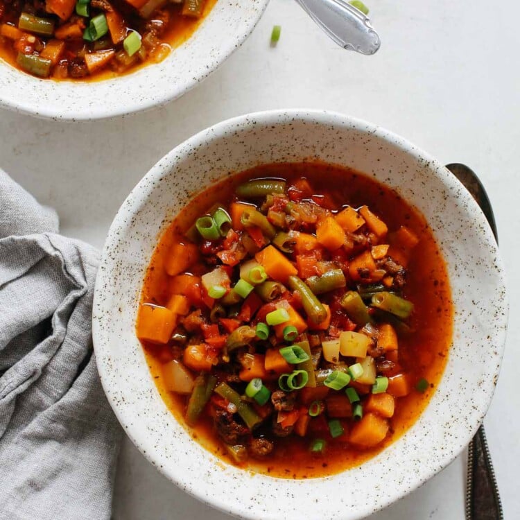 overhead view of a white bowl containing ground beef vegetable soup