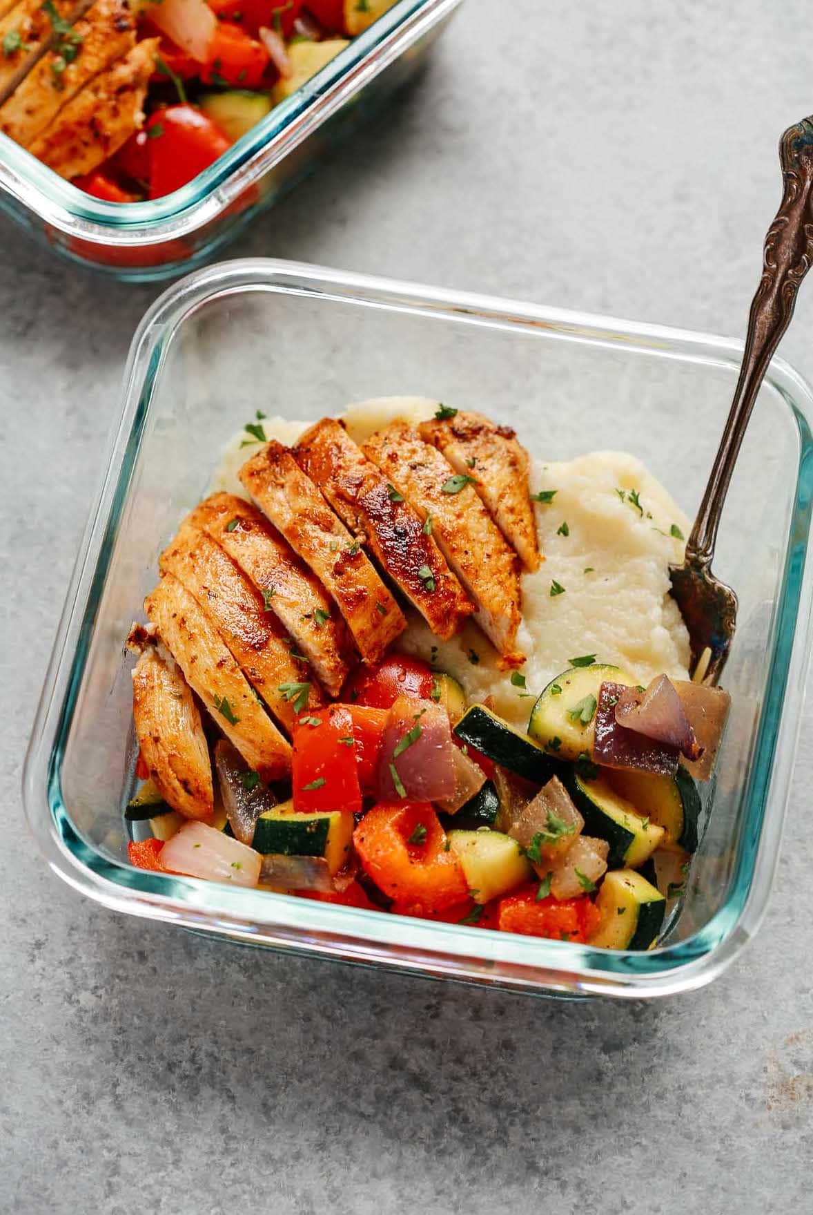 sliced baked chicken breast, cooked mixed vegetables and cauliflower mashed potatoes in square glass meal prep container