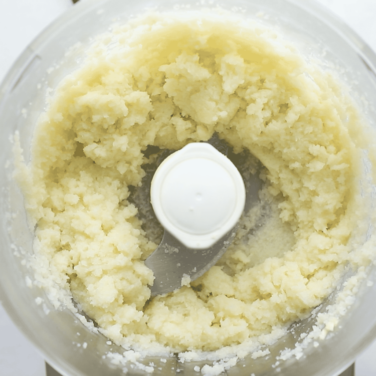 overhead view of a food processor containing cauliflower
