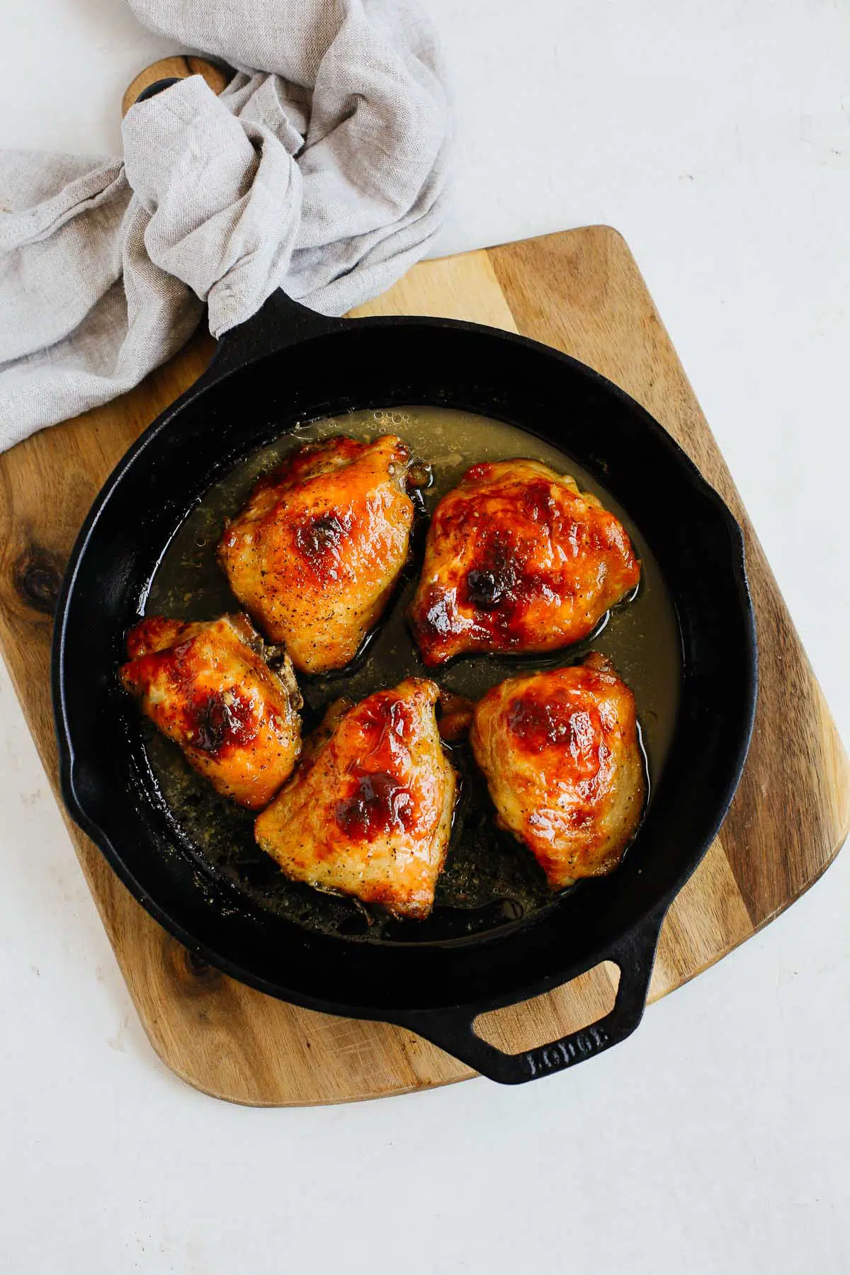 overhead view of a cast iron skillet containing Dijon Chicken Thighs