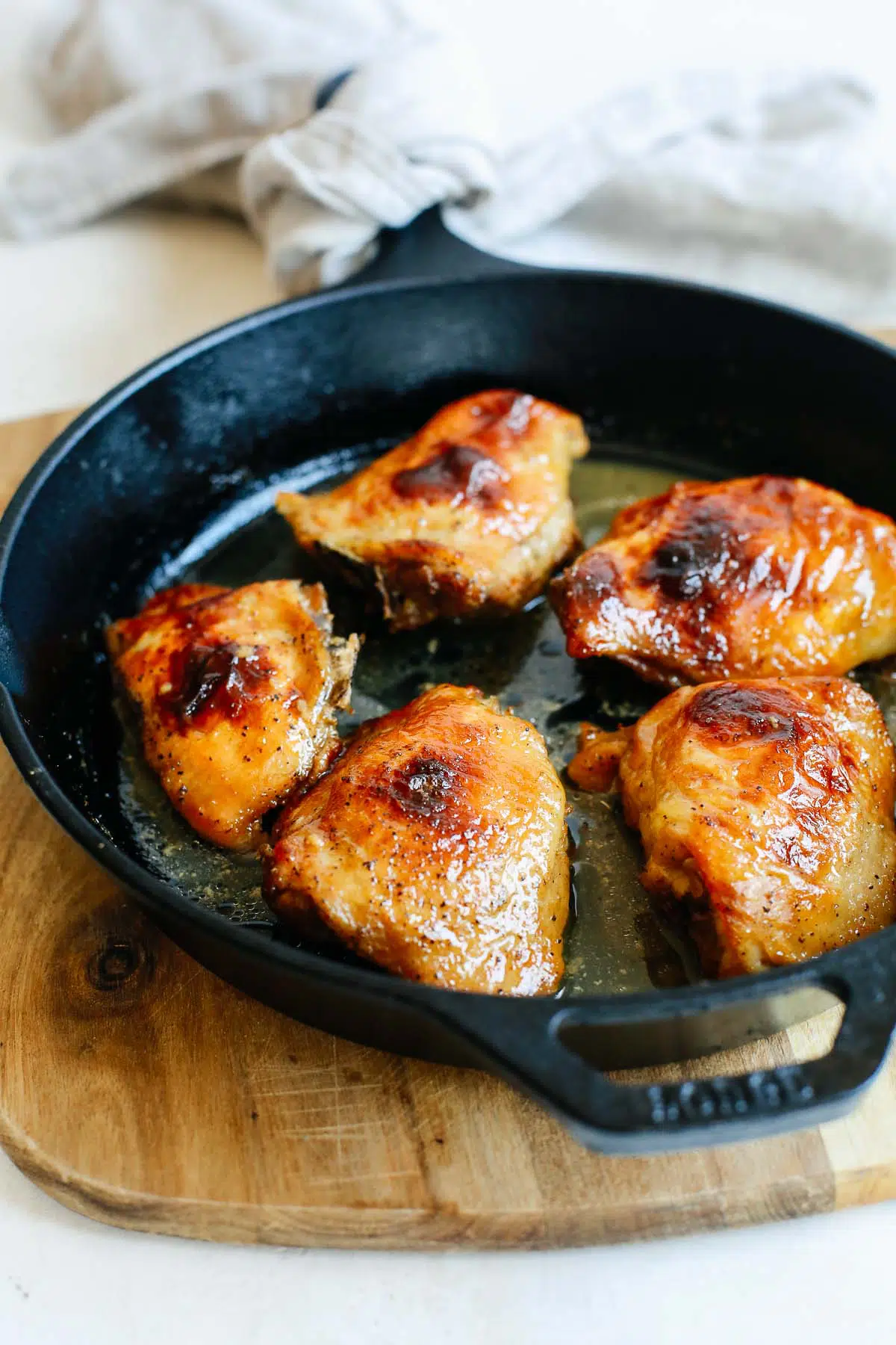 close up of baked chicken thighs in a skillet
